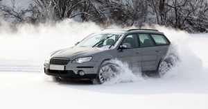extreme driving, the car is moving rapidly over the smooth snow and creates a spray of snow