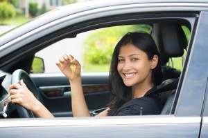 Closeup portrait, young cheerful, joyful, smiling, gorgeous woman holding up keys to her first new car