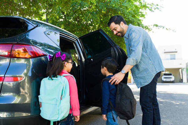 Father and children pile into the car to head back to school