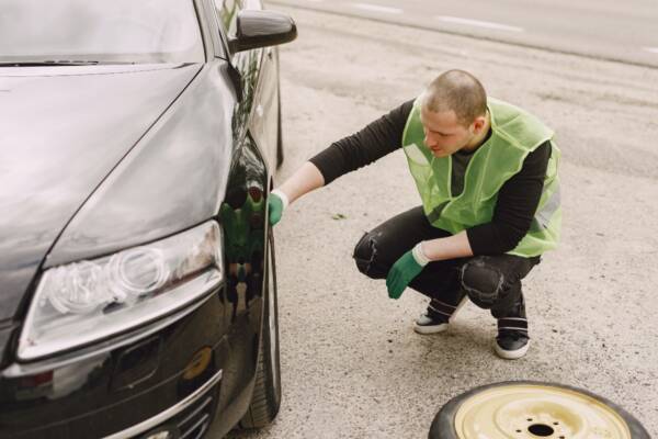 Man checking for a car fluid leak after an accident