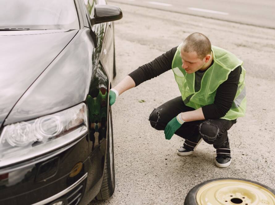 Man checking for a car fluid leak after an accident
