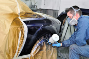 worker completing collision repair on a vehicle